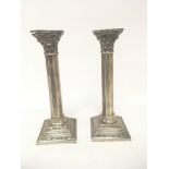 A pair of silver candle sticks in the form of Cori