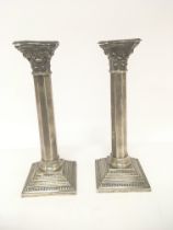 A pair of silver candle sticks in the form of Cori