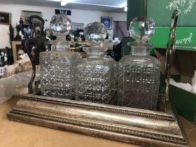 A silver plated tantalus inset with three glass decanters