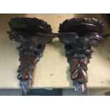 A pair of carved wall brackets in the form of eagl