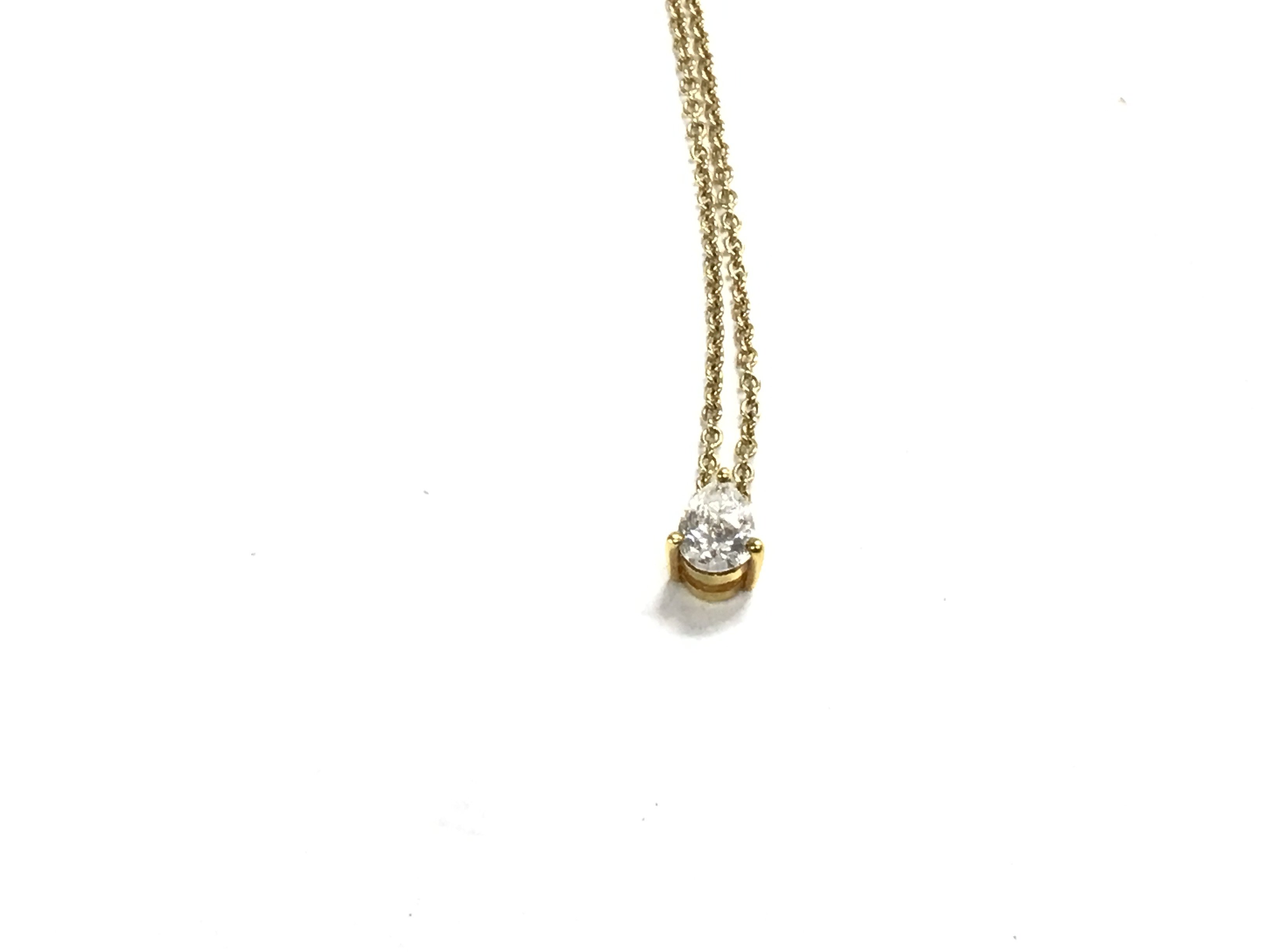 An 9ct gold pear shaped diamond pendant with chain