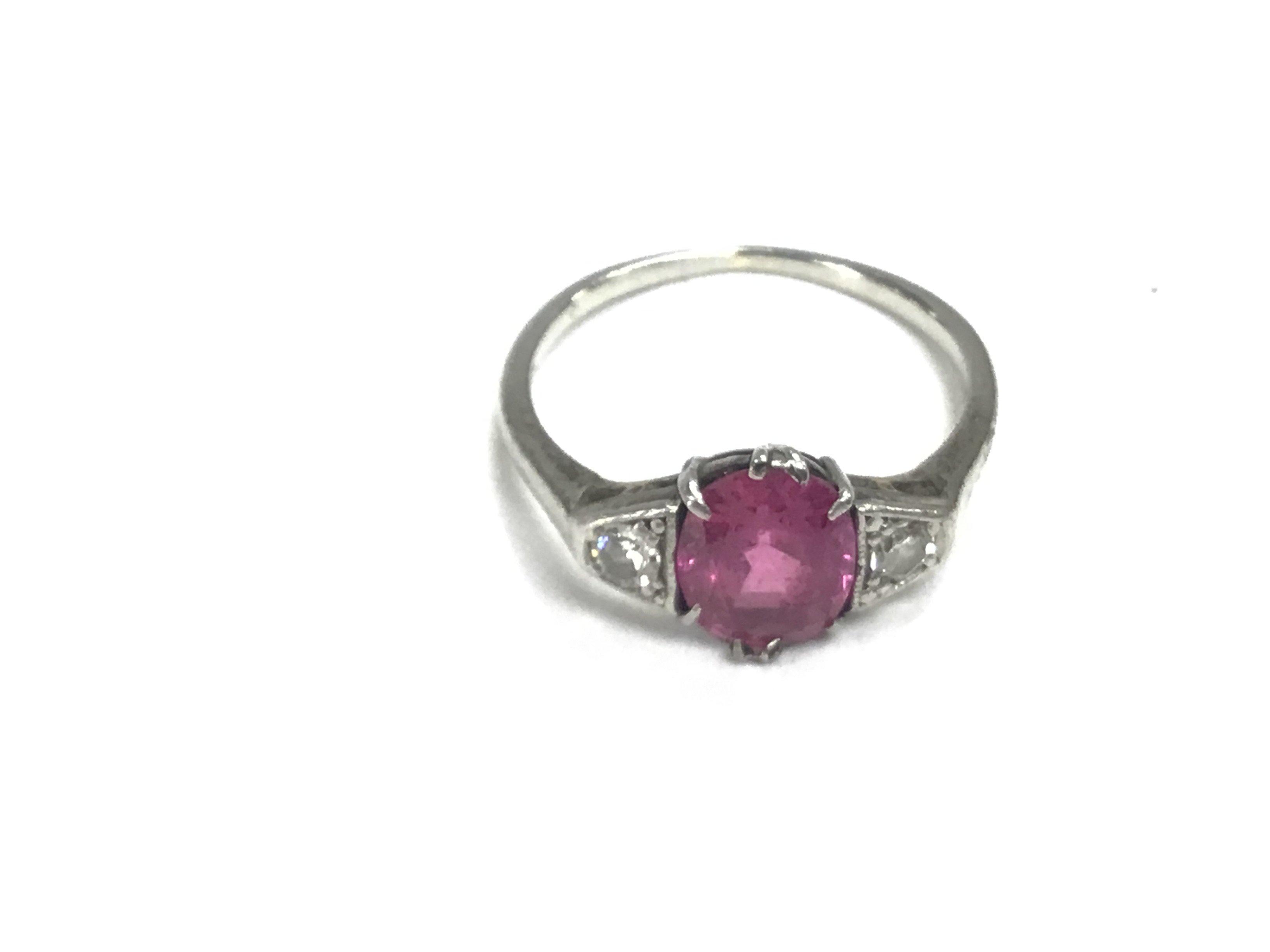 A platinum ring set with a central ruby and white