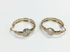 A pair of 9ct gold hoop earrings set with CZ heart