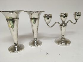 A pair of silver vases with loaded bases and a silver candelabra Birmingham hallmarks. (3)