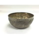 A white metal dish, exterior in Indian silver with embossed landscape decoration with figures in a