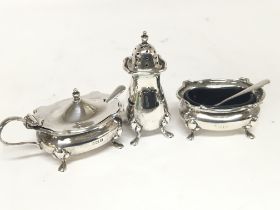 A three piece silver condiment set.