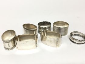 A collection of silver napkin rings mixed patterns and hallmarks (7)