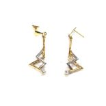 A pair of gold earrings set with a diamond. Total