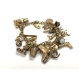 A 9ct gold charm bracelet with a large number of c