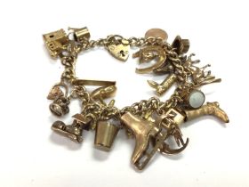 A 9ct gold charm bracelet with a large number of c