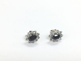 A pair of 9ct gold, sapphire and white stone set e