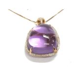 A large amethyst pendant surrounded by diamonds se