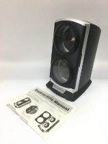 An automatic watch winder in black with instructions. Shipping category D.