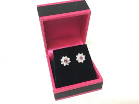 A pair of white gold daisy earrings set with diamo