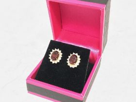 A pair of 14 Carat gold earrings set with a centra