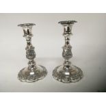 A pair of silver plated candle sticks the stems with stylised acanthus leaves shaped bases height