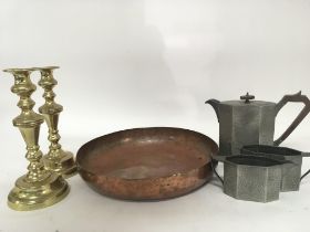 A pair of brass candle sticks a large copper bowl and a pewter tea set