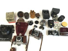 A collection of various cameras Hauna 35x contaflex Zeiss ikon four lenses and additional equipment.