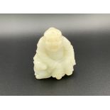 A small carved jade figure of a Chinese deity seat