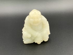 A small carved jade figure of a Chinese deity seat