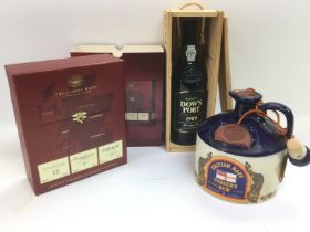 A boxed collection of three single malt whiskeys, a bottle of Pusser's Rum and a boxed bottle of1989