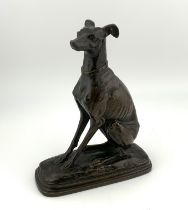 A small cast bronze figure of a. Seated Whippet impressed signature E.Salmon. (B)