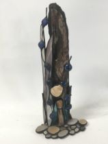 An unusual contemporary sculpture with drift wood and applied pewter polish pebble and blue