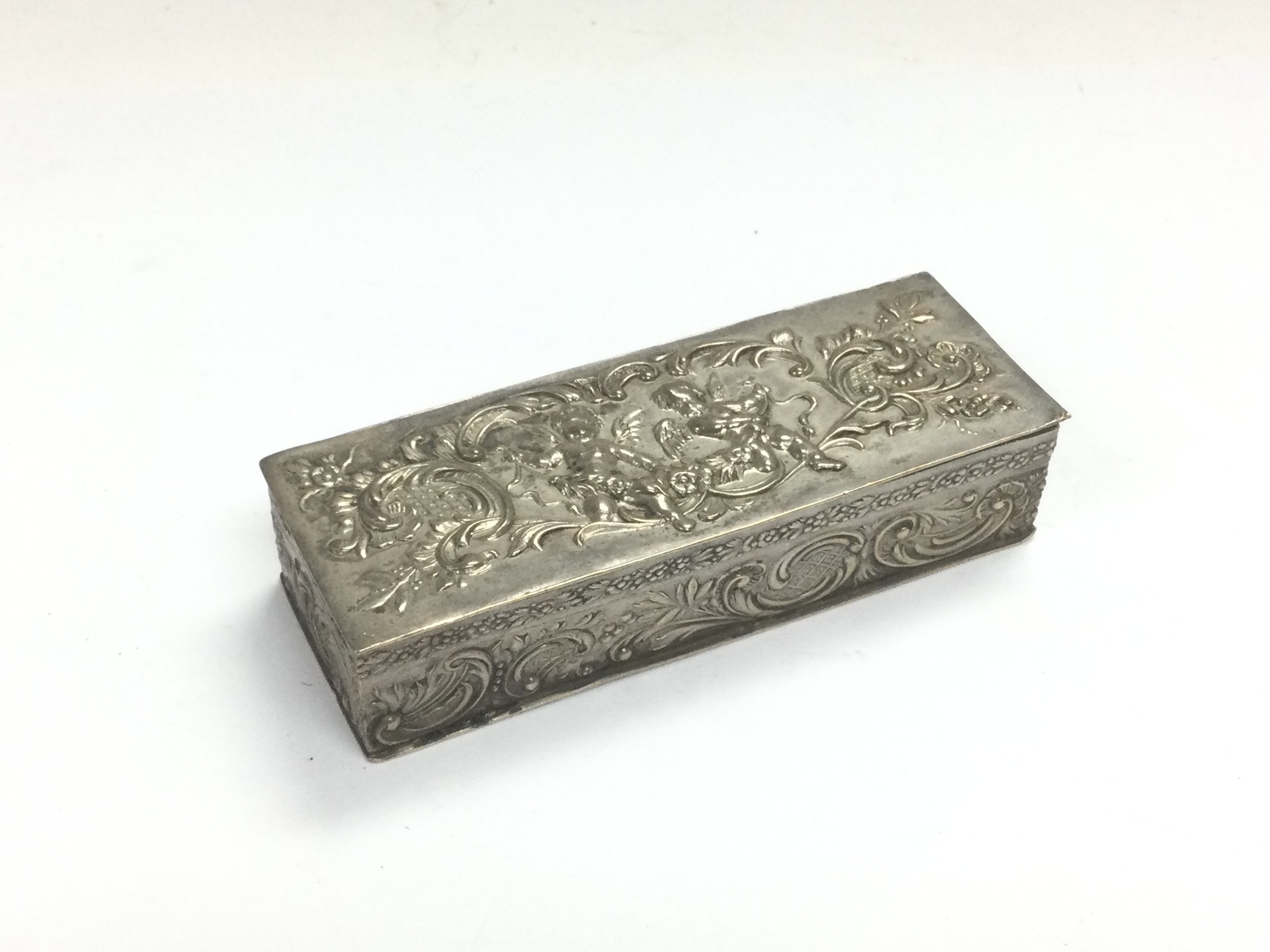 A small Continental silver box decorated with putti, approx 7.5cm x 2cm x 3cm. Shipping category