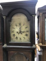 A oak eight day cased long case clock the a the arched dial with Roman numerals.