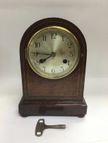 An eight day inlaid mahogany mantle clock, approx height 26cm. Comes supplied with key. Shipping