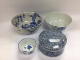 Four blue and white china items comprising three bowls and a circular pot and cover, largest bowl