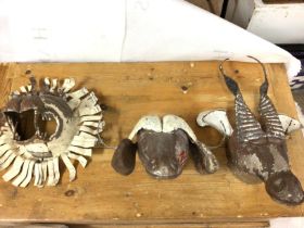 Three metal wall masks including a buffalo and lion. Approximately 40cm in diameter. Postage D