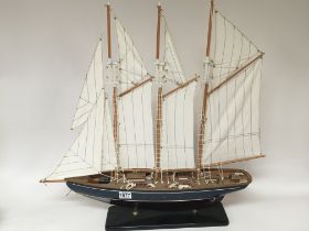 A painted wood model of a sailing ship in full sal
