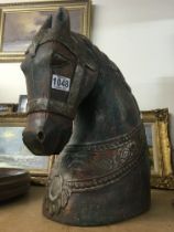 A carved horses head with applied brass mounts. Me