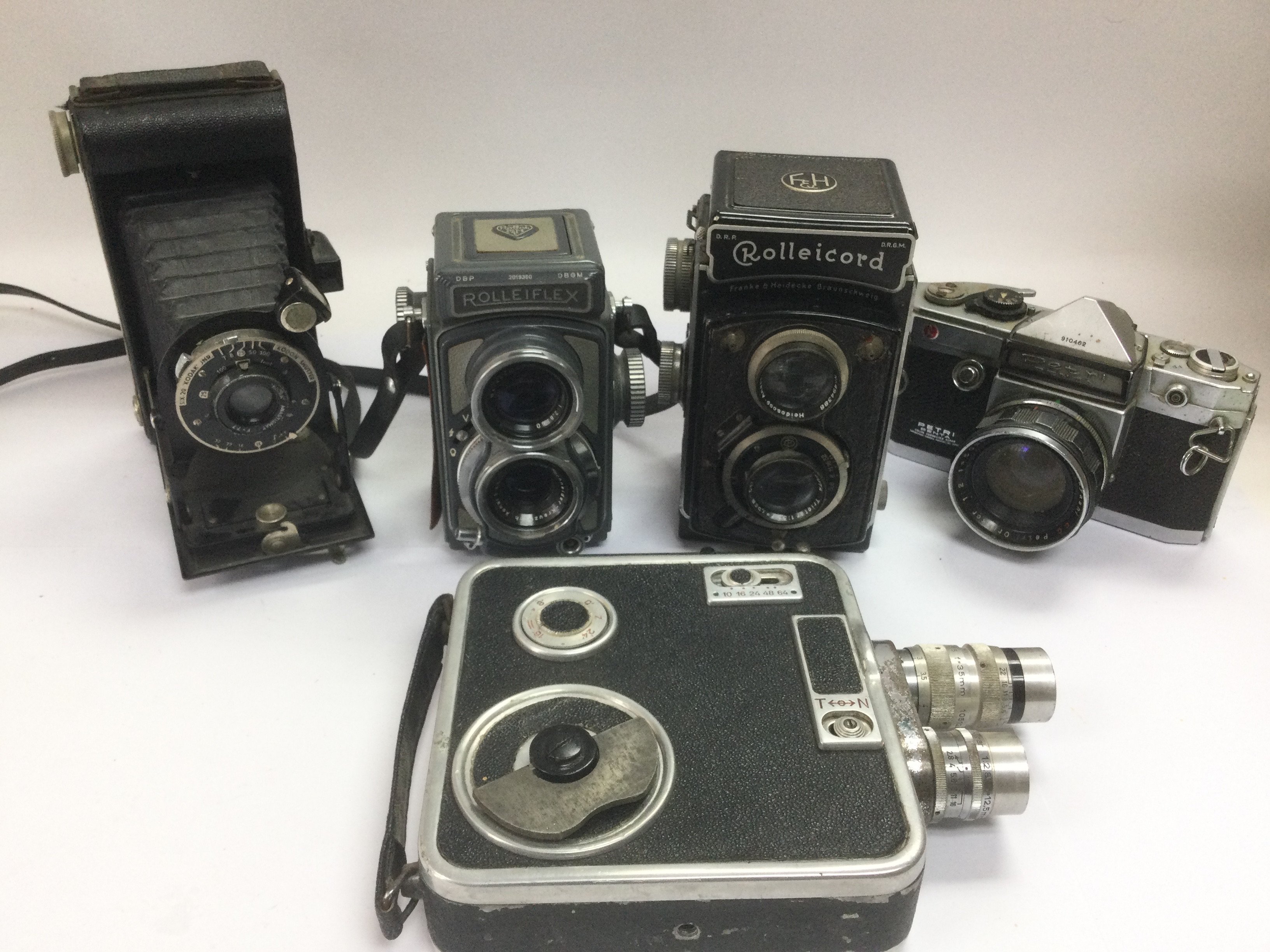 A box of vintage cameras including a Rolleiflex, Rolleicord, Kodak Six 20 and others. Shipping