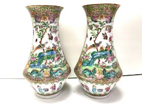 A pair of Cantonese porcelain baluster shaped vases. 25cm (D) some damage to rim.