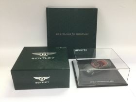 A boxed die cast model of a Bentley Continental GTC Speed together with a Brietling for Bentley book