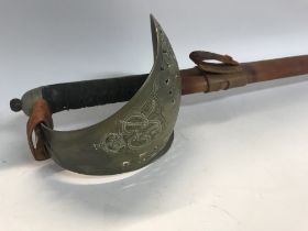 A cavalry sword with engraved blade and leather scabbard