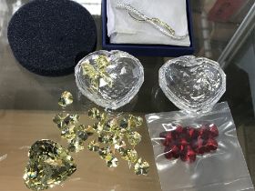 Two Swarovski heart shaped trinket boxes, together with loose hearts in yellow and red. Also a boxed