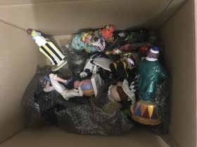 A box of ceramic clown figures and clown toys.