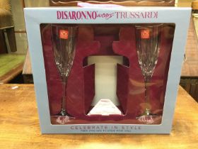 2 Italian glass flutes, part of a Disaronno wears Trussardi gift set. Bottle of Diasaronno