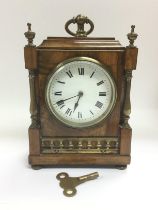 A walnut mantle clock with brass fittings, approx height 21cm. Comes supplied with a key. Shipping