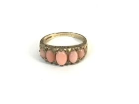 A 9ct gold ring set with pink coral. Size Q and 3.