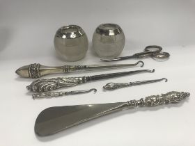 A collection of silver items including match strik