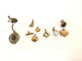A collection of 9ct gold pendants and charms. Tota