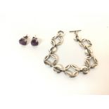 Sterling silver stud earrings set with a purple ge