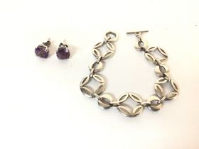 Sterling silver stud earrings set with a purple ge