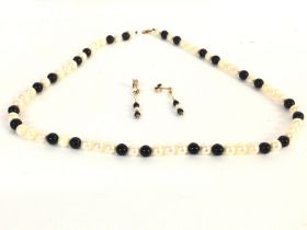 A Milkimoto black pearl necklace with conforming d