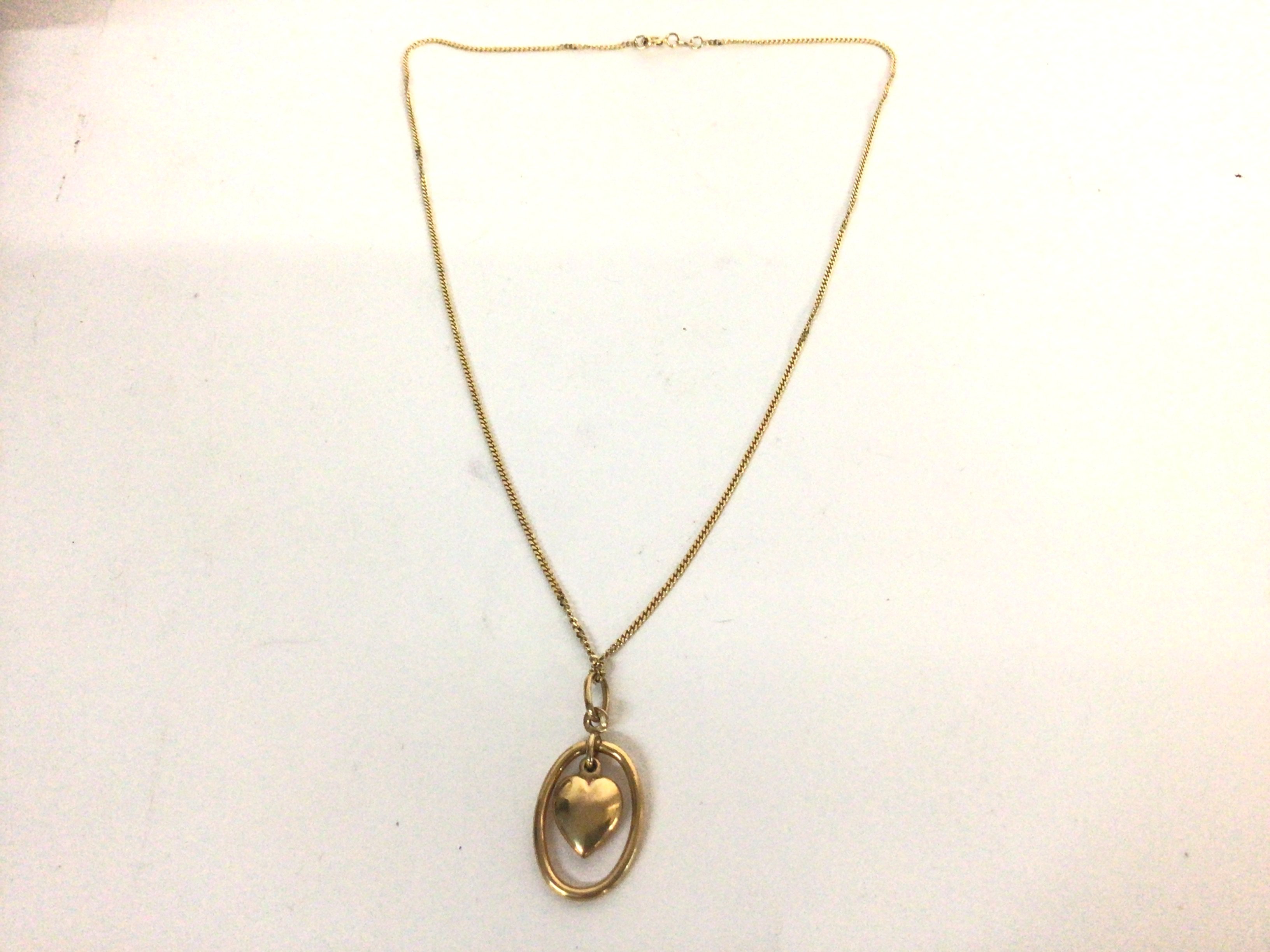 An 18ct gold necklace set with attached heart pend