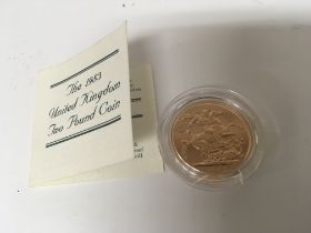 A gold 1983 proof Two pound coin in a plastic case